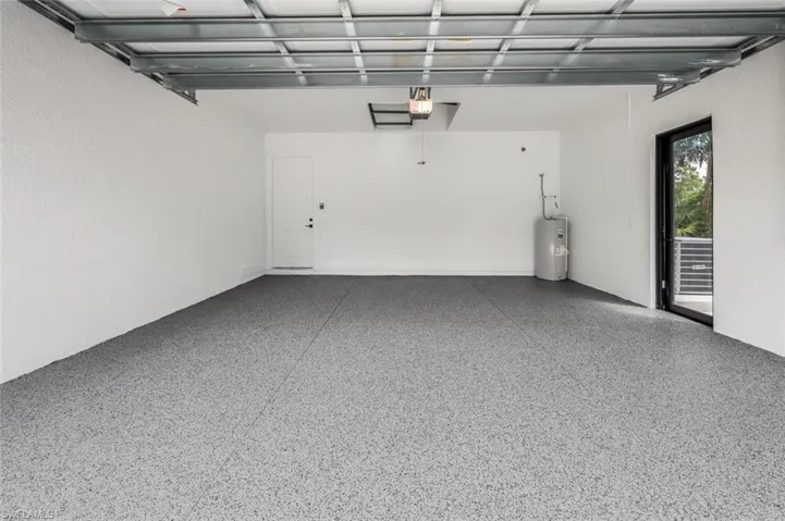 Garage featuring water heater and a garage door opener
