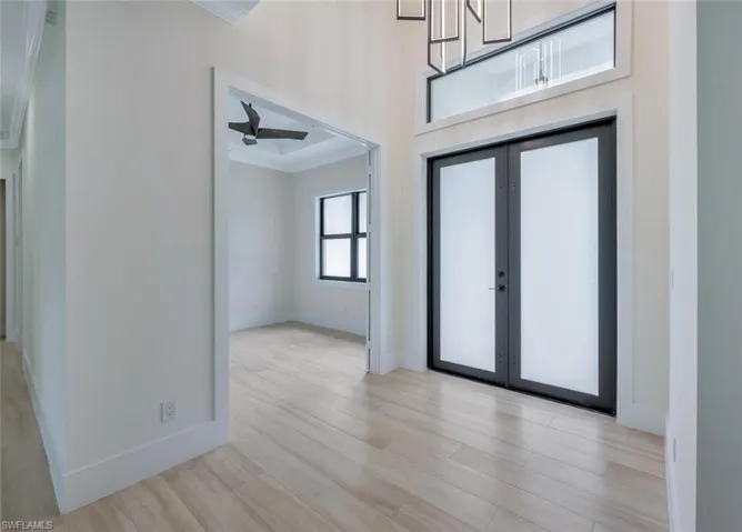 Entrance foyer featuring french doors, baseboards, ceiling fan, and wood finished floors