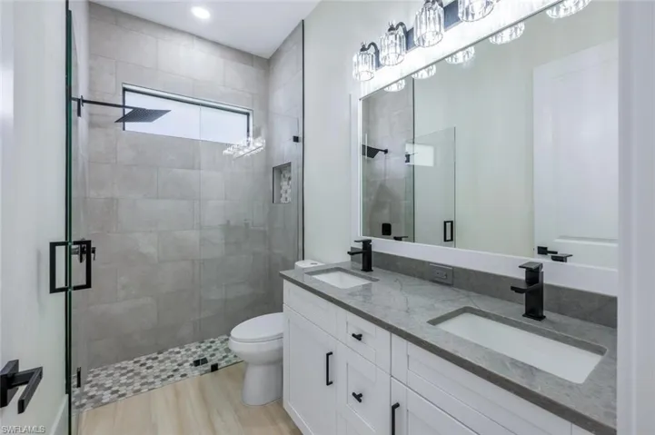 Full bathroom featuring toilet, a sink, and a stall shower