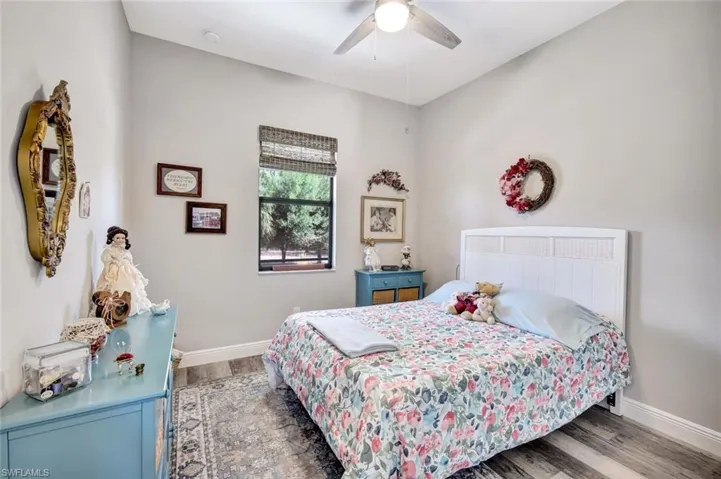 Bedroom with wood finished floors, baseboards, and a ceiling fan