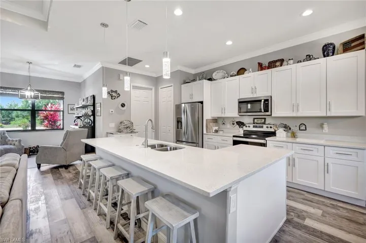 Kitchen featuring appliances with stainless steel finishes, a sink, open floor plan, light wood-style floors, and recessed lighting