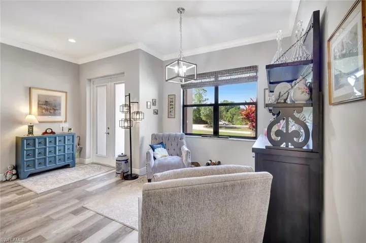 Living area featuring wood finished floors, a chandelier, ornamental molding, recessed lighting, and baseboards