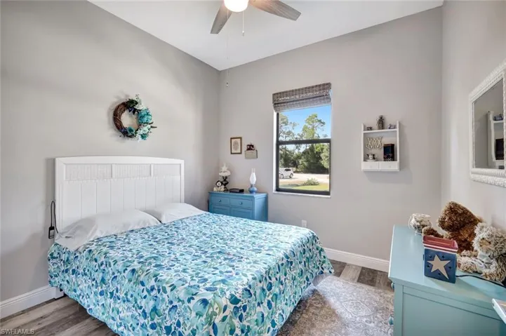 Bedroom featuring wood finished floors, baseboards, and ceiling fan