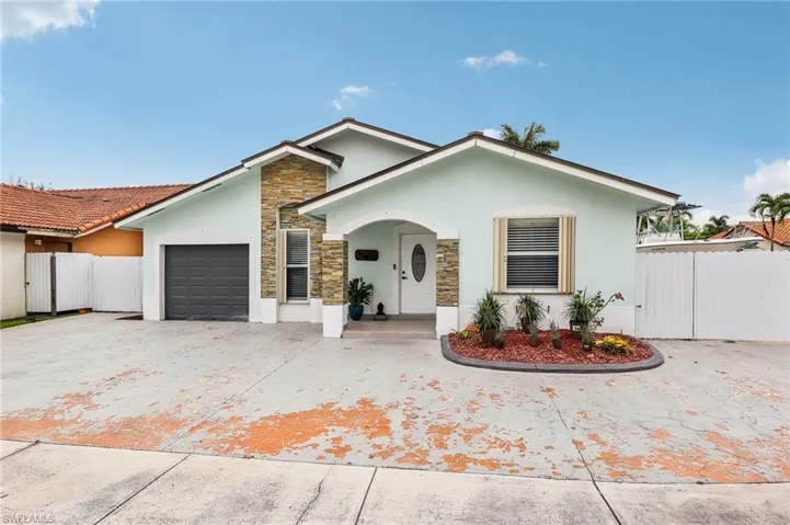 Single story home featuring a garage and ample parking