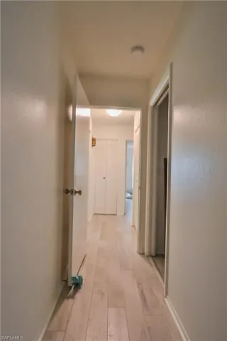 Corridor with light hardwood / wood-style flooring