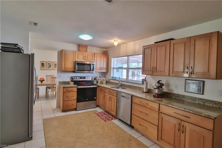 Kitchen with stainless steel appliances, sink, and light tile patterned floors