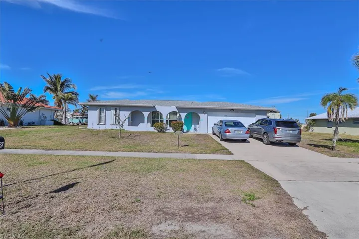 Ranch-style home with a garage and a front lawn