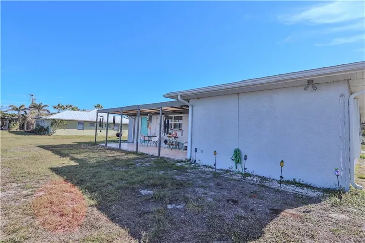 View of property exterior featuring a patio area and a lawn
