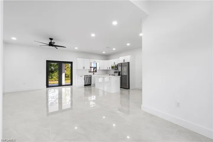 Unfurnished living room featuring french doors and ceiling fan