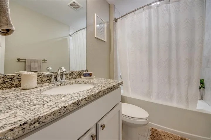 Full bath with vanity, shower / bath combination with curtain, and tile patterned flooring