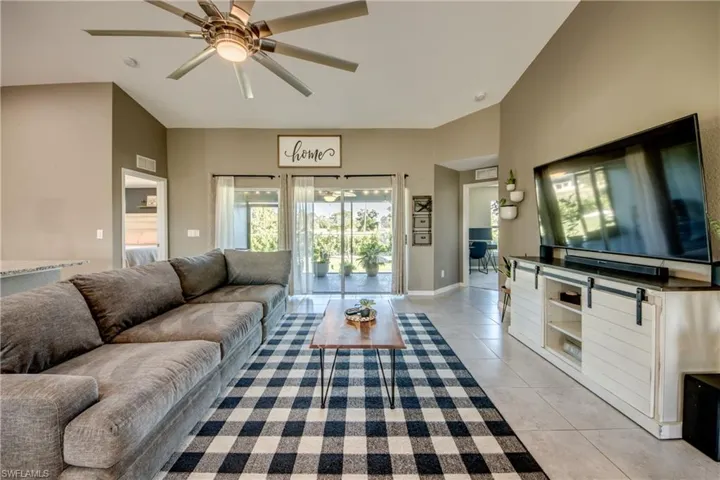 Living area featuring light tile patterned floors and a ceiling fan