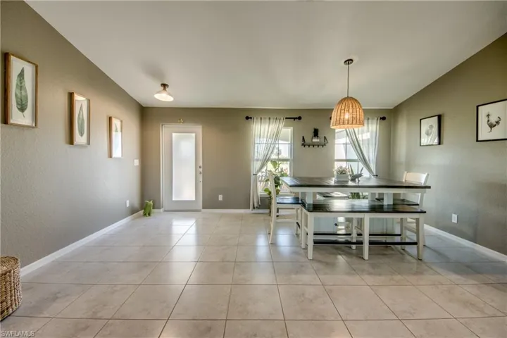 Dining area with light tile patterned flooring and a textured wall