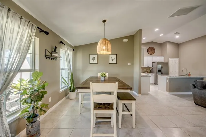 Dining area featuring vaulted ceiling and light tile patterned floors
