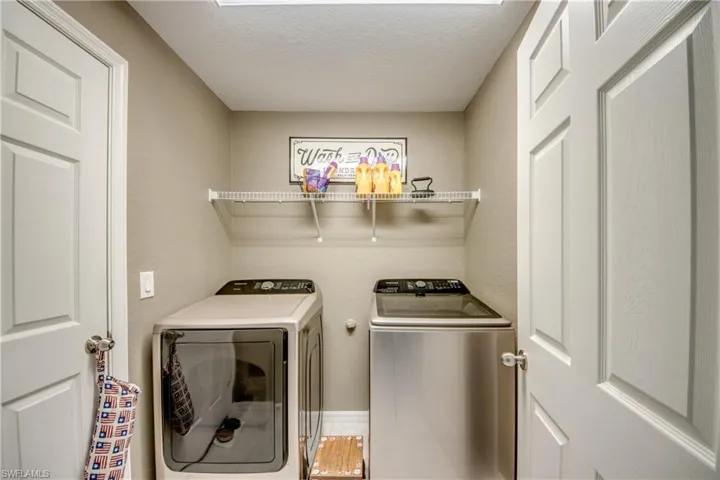 Washroom with washing machine and dryer and a textured ceiling