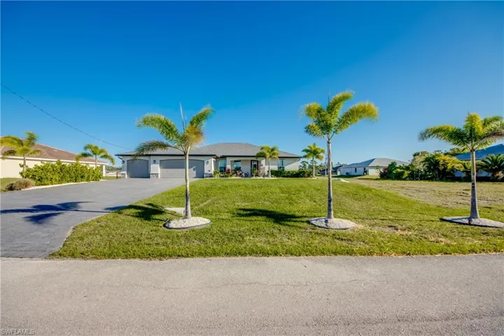 Ranch-style house featuring an attached garage, driveway, and a front yard