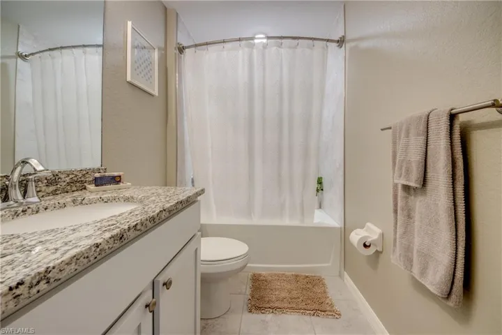 Full bath featuring vanity, tile patterned floors, and shower / tub combo with curtain