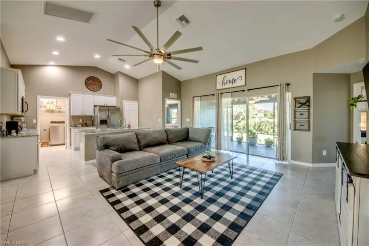 Living room featuring high vaulted ceiling, ceiling fan, light tile patterned floors, washer / clothes dryer, and recessed lighting