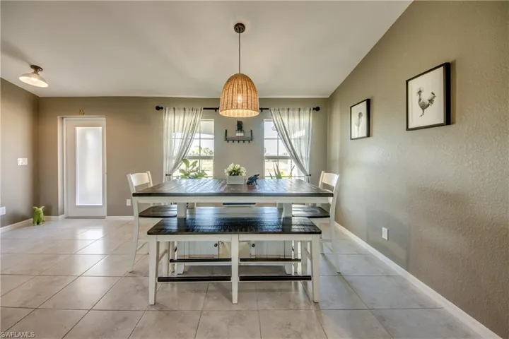 Dining area with light tile patterned floors and a textured wall