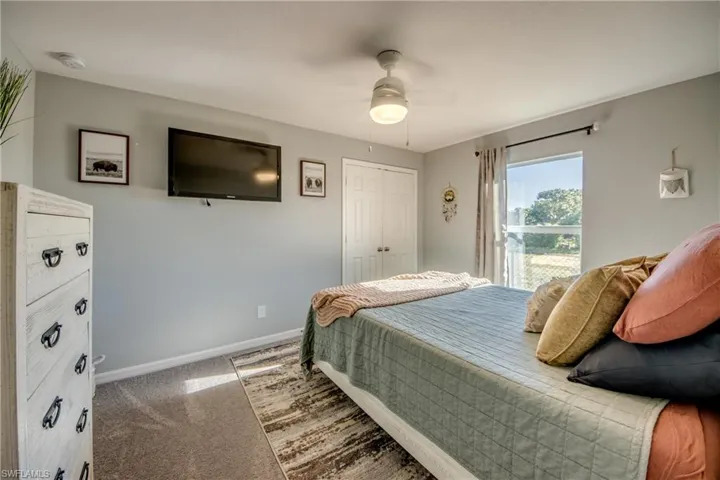 Carpeted bedroom with a closet and ceiling fan
