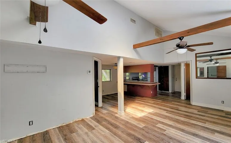 Living room with ceiling fan, beam ceiling, light hardwood / wood-style floors, and high vaulted ceiling