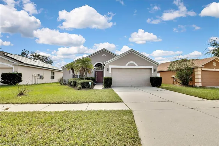 Ranch-style home with a garage and a front lawn