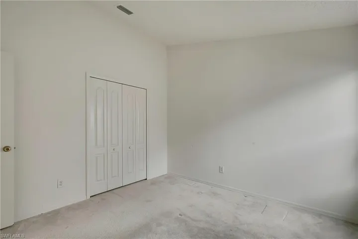 Unfurnished bedroom featuring light colored carpet and a closet