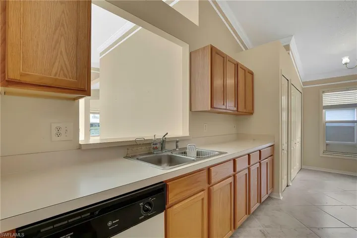 Kitchen featuring dishwasher, plenty of natural light, sink, and crown molding