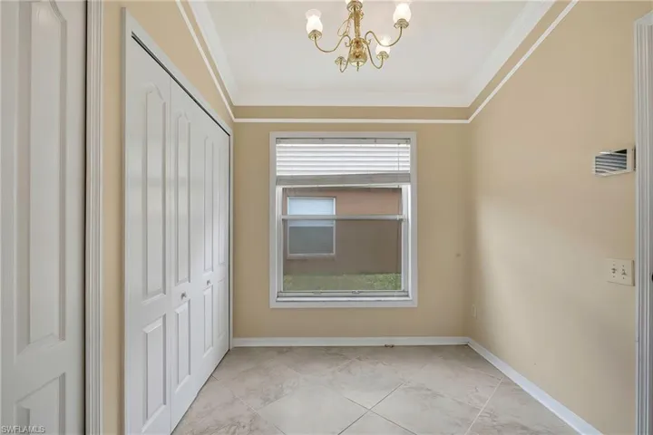 Empty room featuring ornamental molding and a chandelier