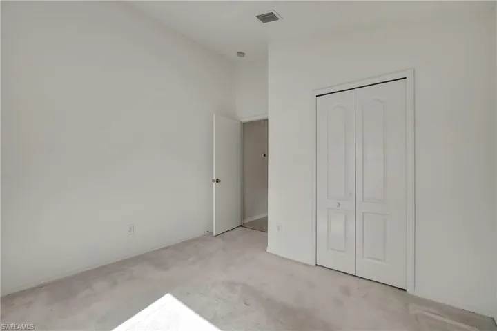 Unfurnished bedroom with a closet and light carpet