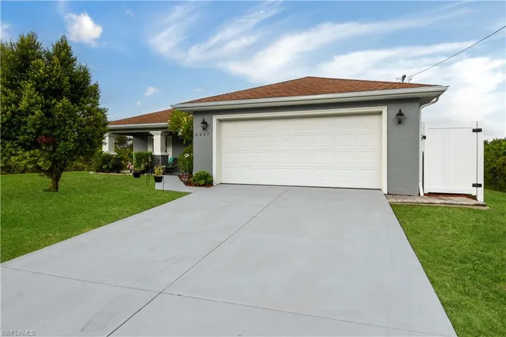 Ranch-style home with a front yard and concrete driveway