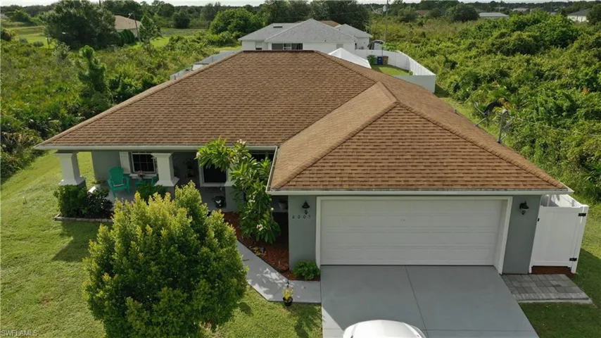 View of front of home with roof with shingles, driveway, an attached garage, and stucco siding