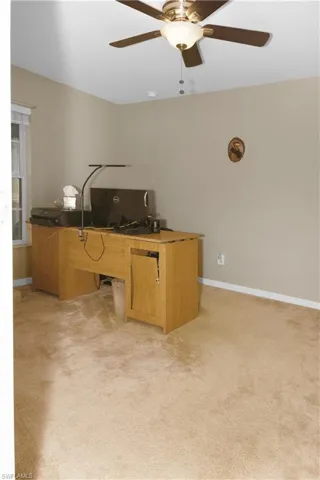 Office space with ceiling fan and light colored carpet