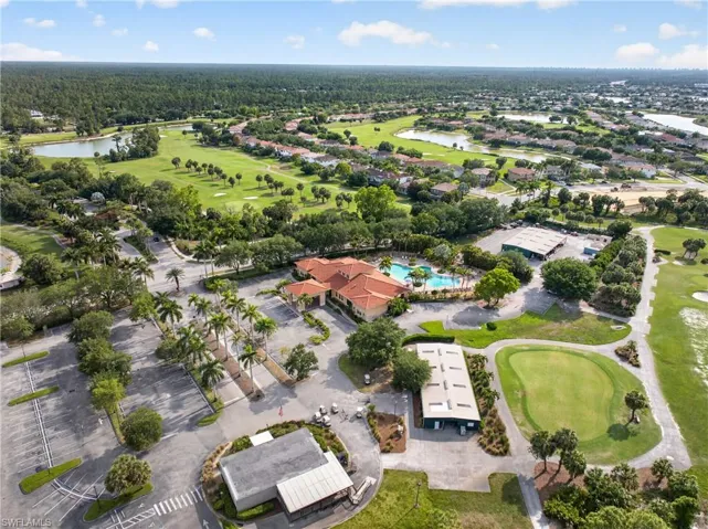 Aerial perspective showcasing a residential community with a central clubhouse featuring a swimming pool