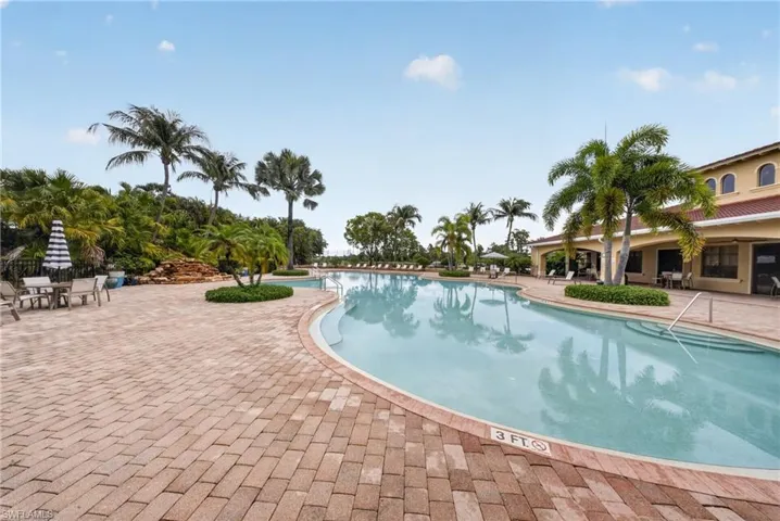 Expansive swimming pool with integrated steps, surrounded by a large paver patio