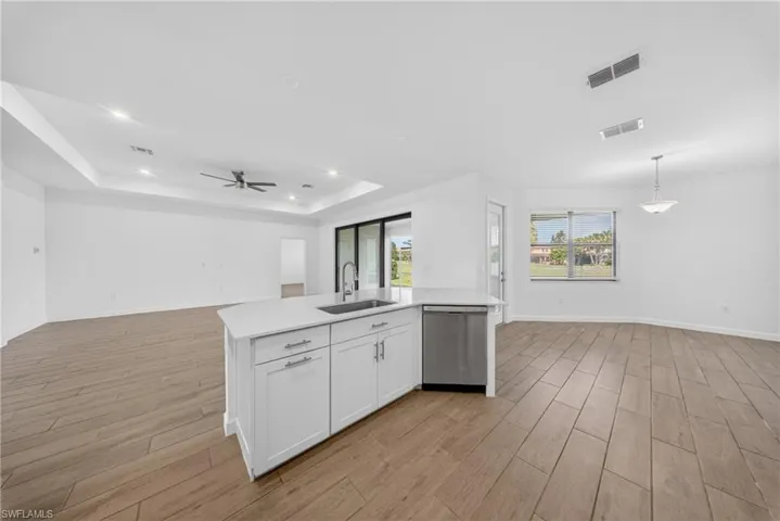 Modern kitchen island featuring a stainless steel sink, gooseneck faucet, and integrated dishwasher
