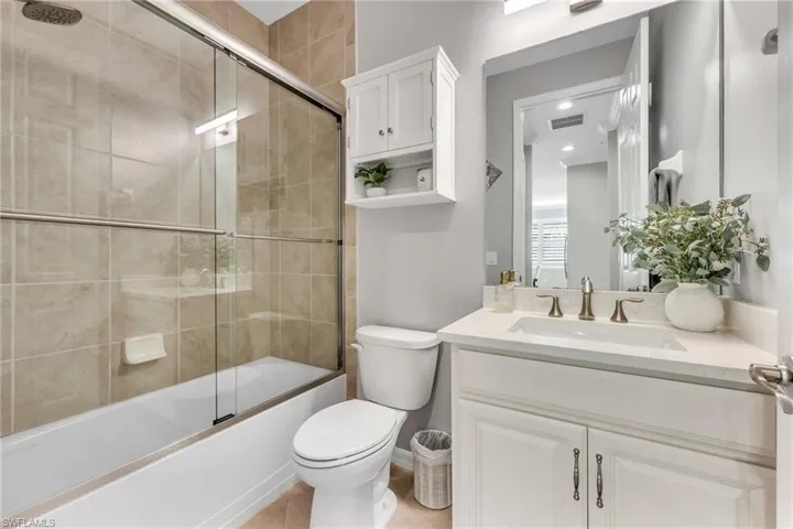 Bathroom featuring vanity and enclosed tub / shower combo