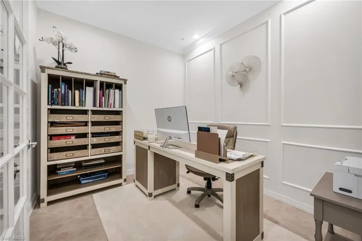 Office area with a decorative wall, light tile patterned floors, crown molding, and recessed lighting