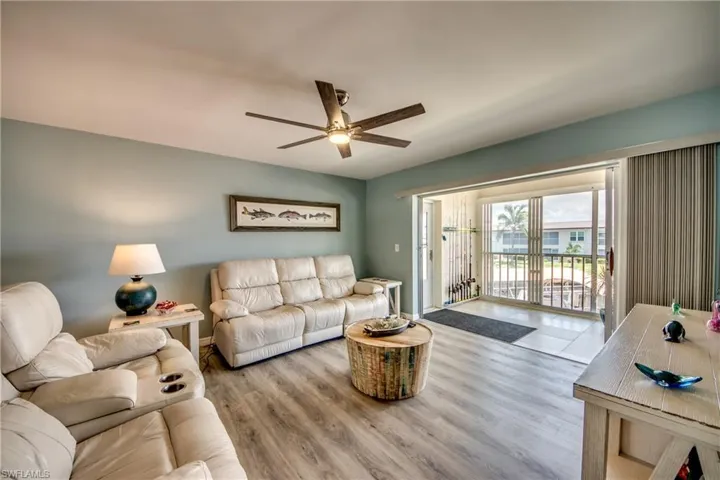 Living room with ceiling fan and hardwood / wood-style flooring