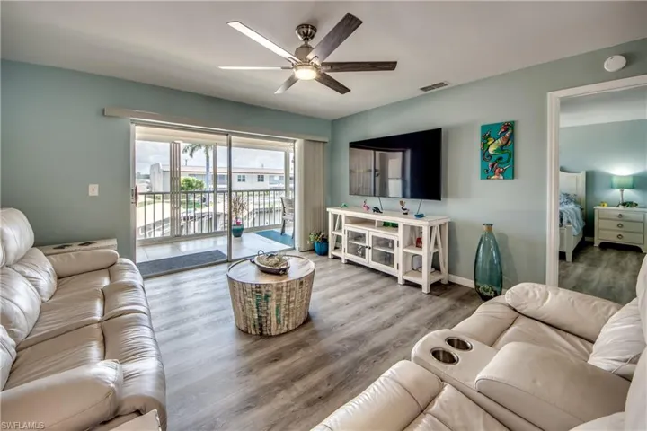 Living room with ceiling fan and hardwood / wood-style flooring
