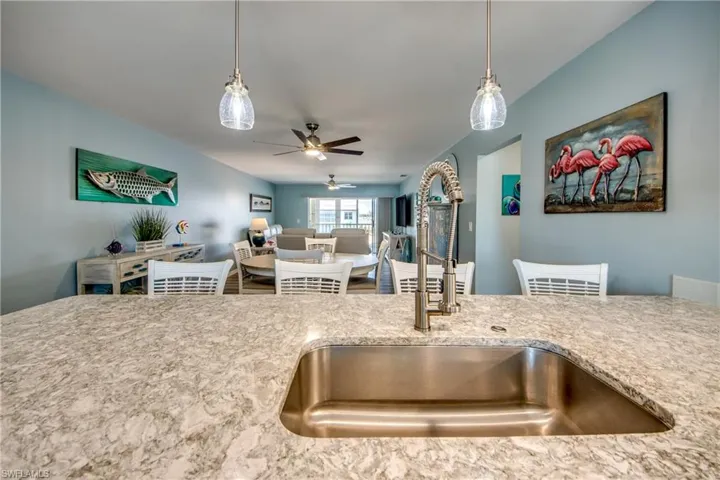 Kitchen with hanging light fixtures, sink, and ceiling fan