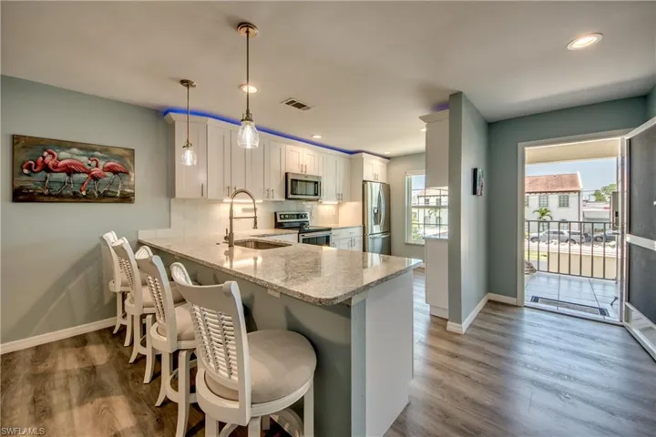 Kitchen featuring appliances with stainless steel finishes, sink, hardwood / wood-style flooring, and pendant lighting