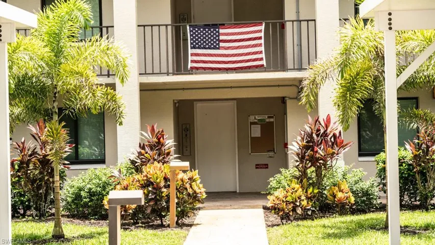 Doorway to property featuring stucco siding and a balcony