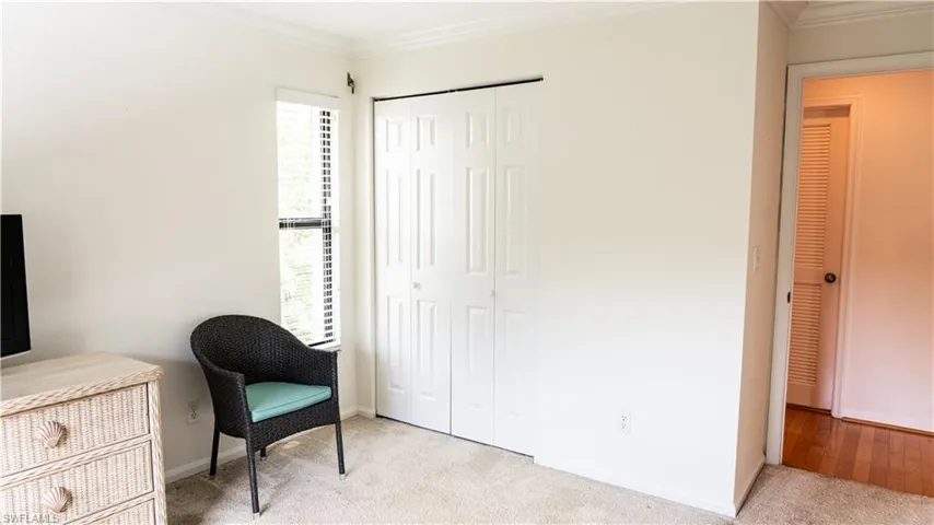Living area featuring crown molding and light colored carpet