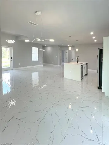 Kitchen with stainless steel refrigerator, a wealth of natural light, and decorative light fixtures