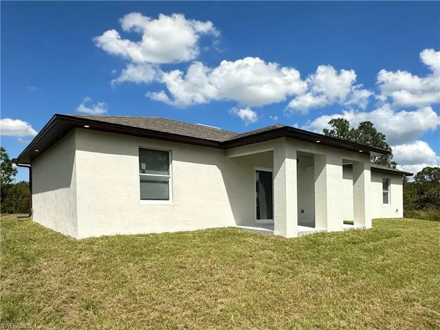 Back of property featuring a lawn