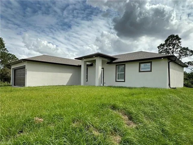 View of front of house with a front yard and a garage