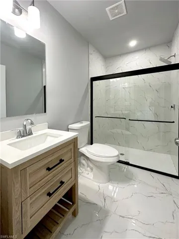 Bathroom with walk in shower, vanity, and toilet