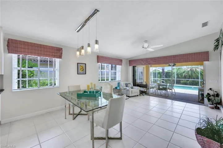 Tiled dining area featuring ceiling fan, lofted ceiling, and a healthy amount of sunlight