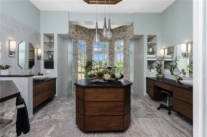 Bathroom with built in shelves, two vanities, and a walk in shower