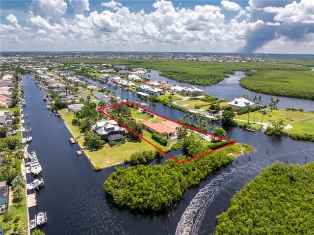 Aerial perspective of suburban area featuring property boundaries highlighted and a large body of water